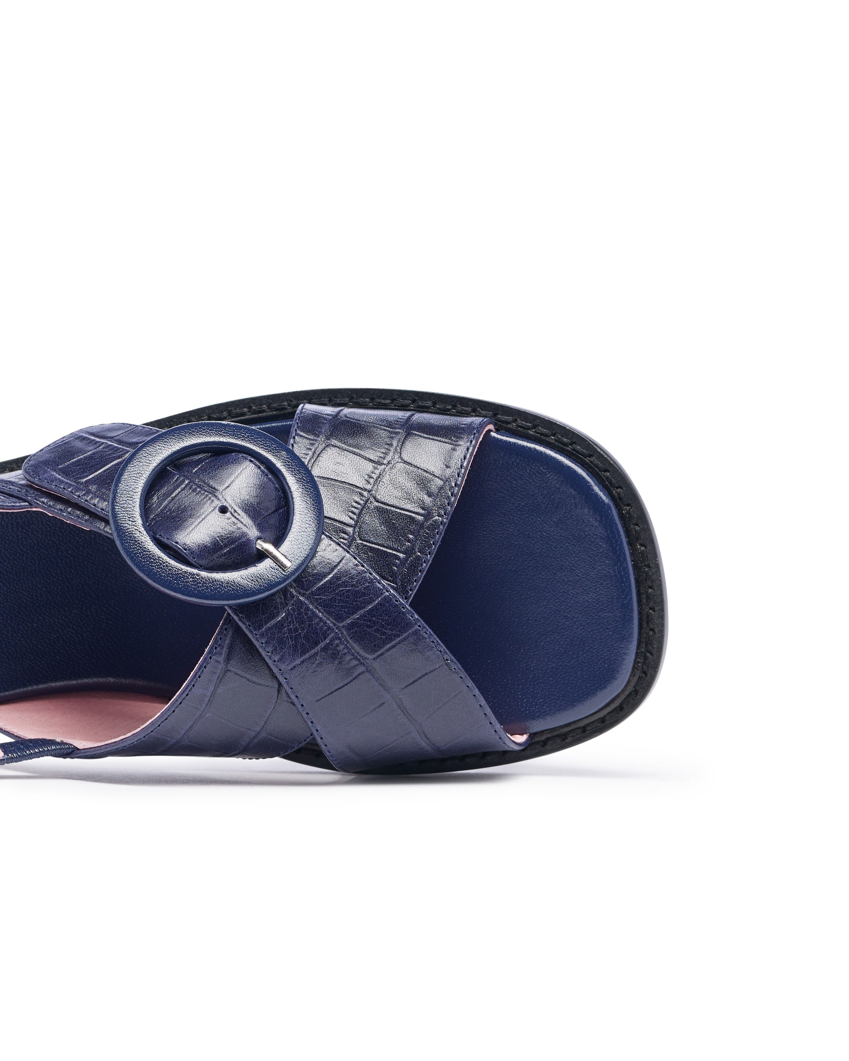 Navy blue sandal with a circular strap on a white background