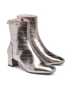 Metallic silver ankle boots on a white background